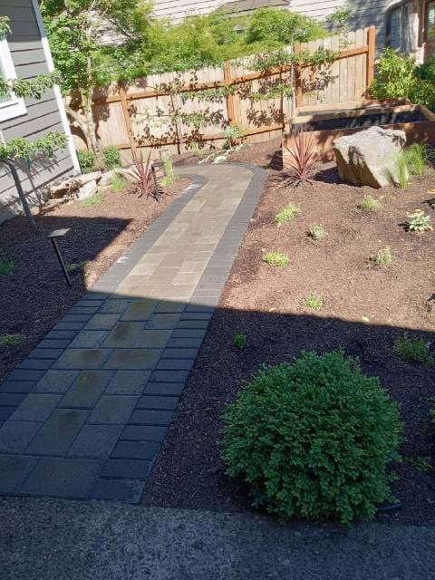 picture of a newly installed paver backyard walkway with beige textured pavers